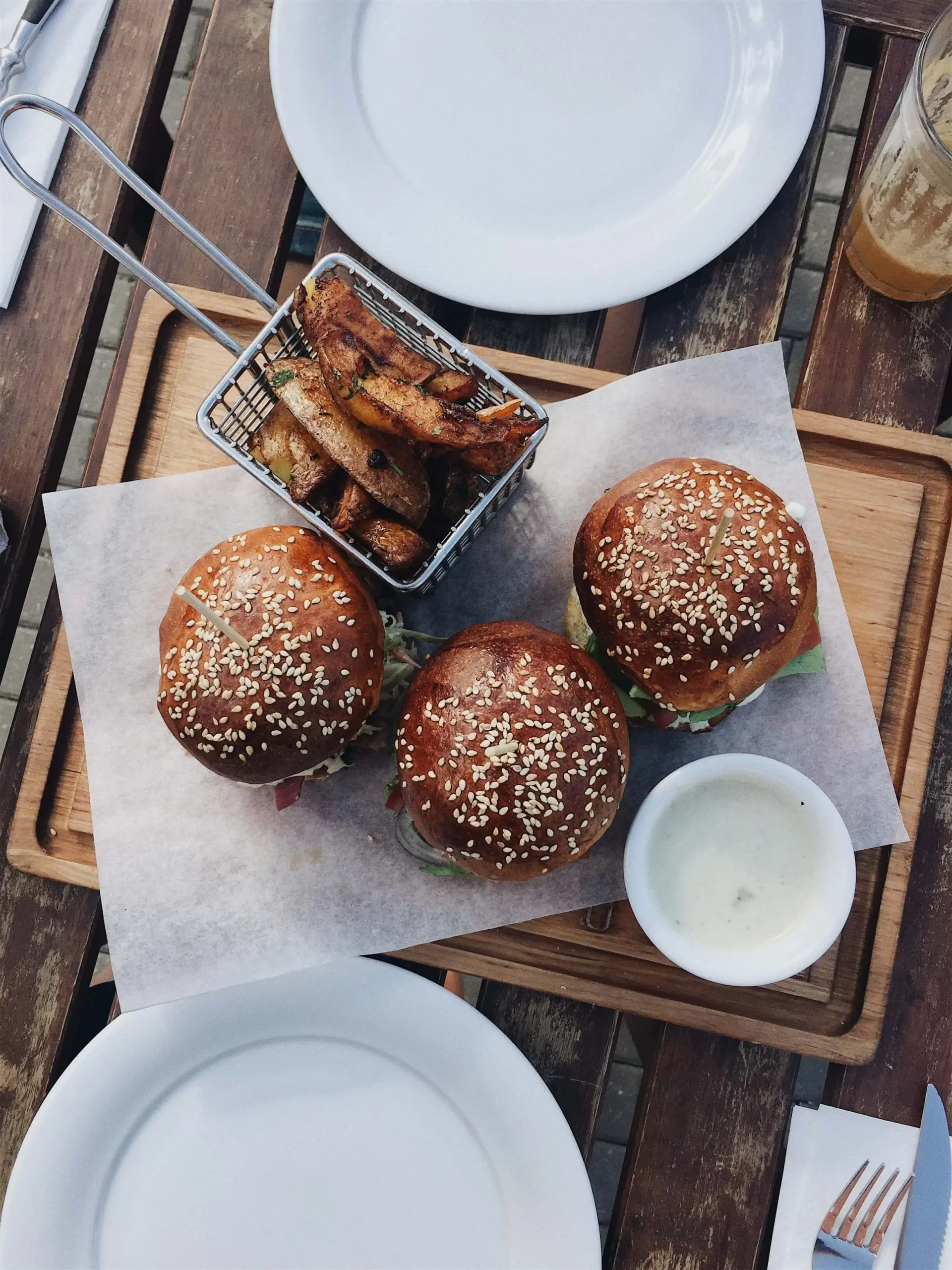 elnienos burgeriai ant medinės lentelės su bulvytėmis